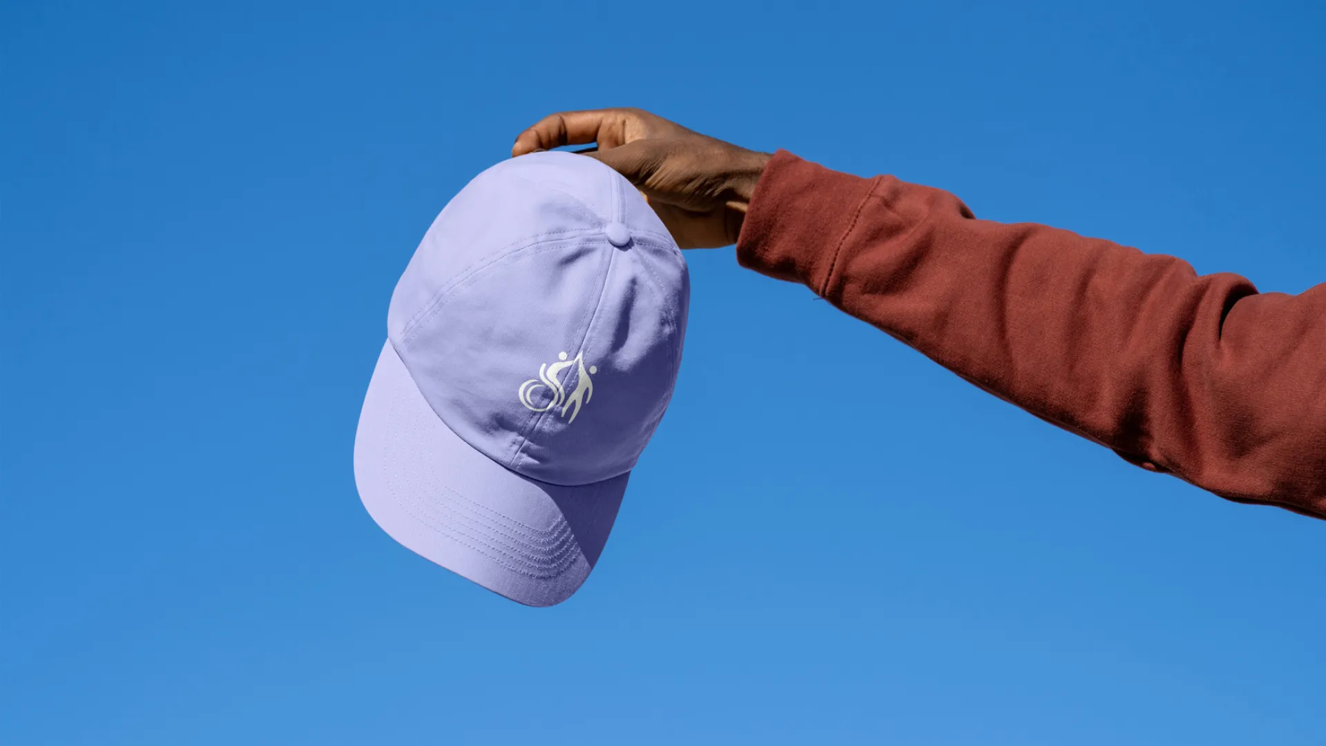 Arm stretched out holding purple cap with Active LD icon