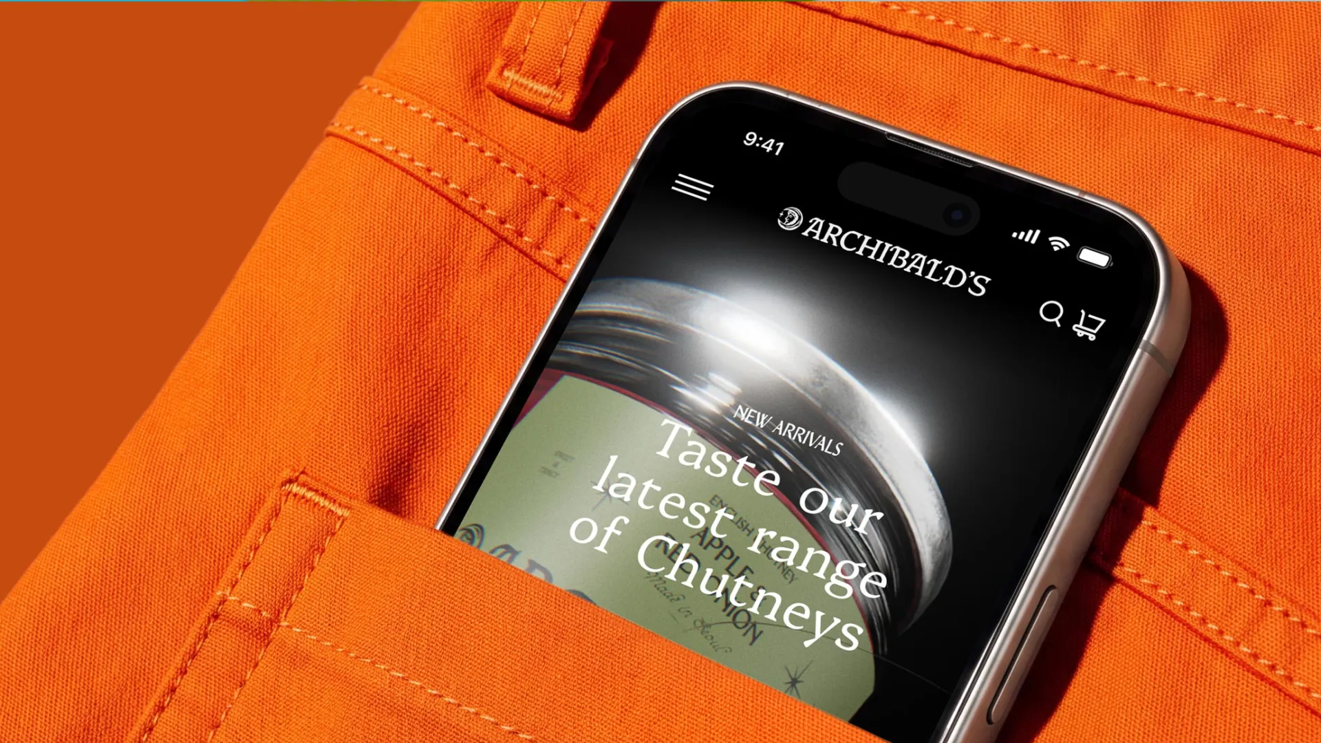 Mobile phone peeping out of a back pocket of bright orange jeans