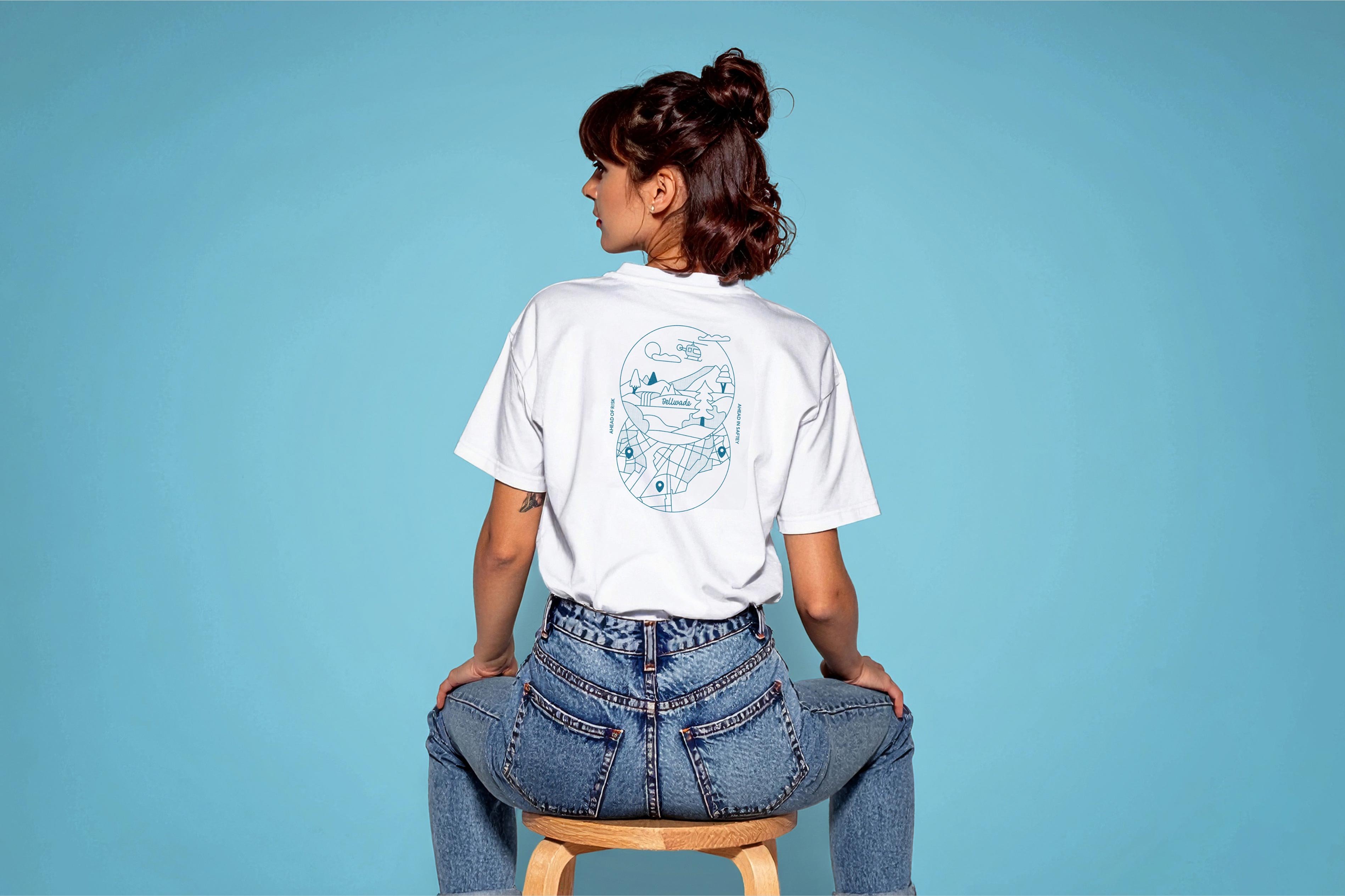 Woman sat on a stall facing away wearing white t-shirt with Bellwade illustration.