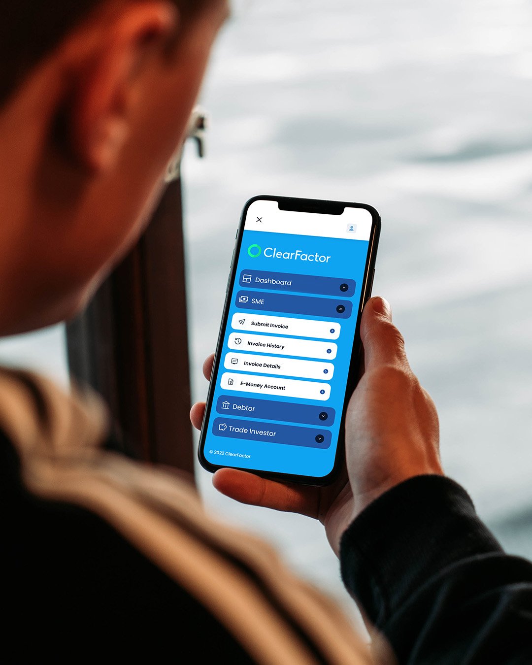 a mobile phone being held with a blue and white webpage on
