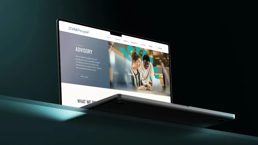 a laptop on a green table with the CVM people website on display