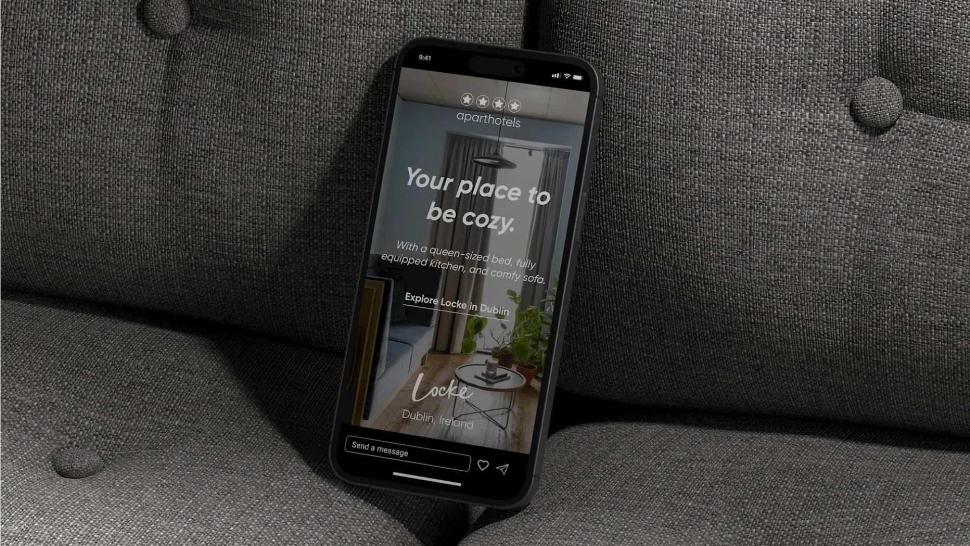Mobile phone mockup leaning on a dark grey sofa.