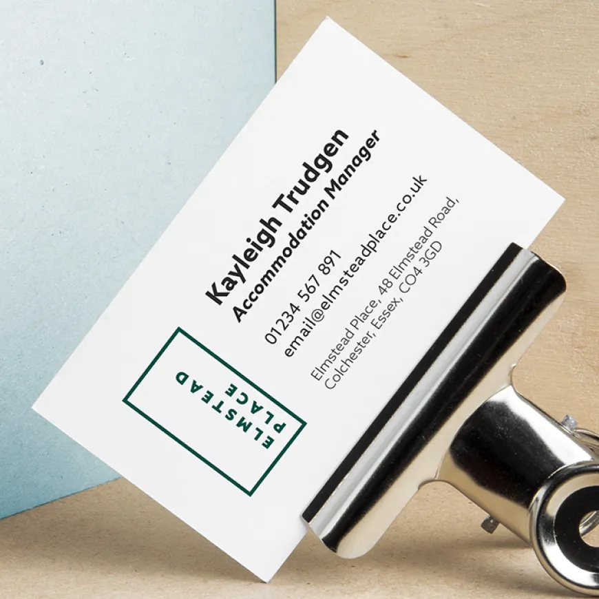 Business card with metal clip, on wooden corner background
