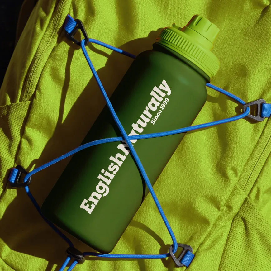 Branded English Naturally water bottle secured to a bright green backpack with blue cords