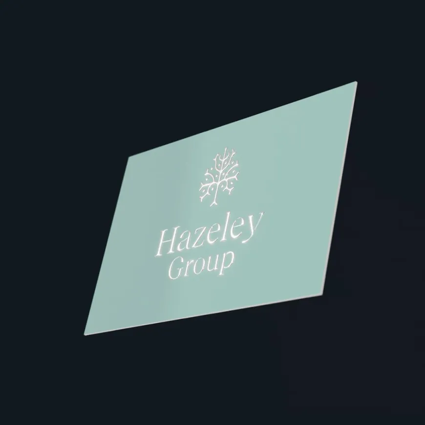 Minimalist Hazeley Group business card with an embossed logo on a soft green background