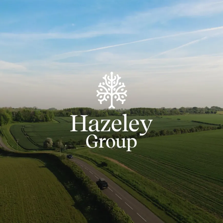 Aerial view of green countryside with the Hazeley Group logo centred over a winding rural road