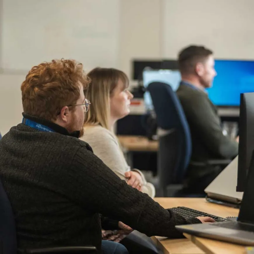 Office employees sat at a desk working on the computer
