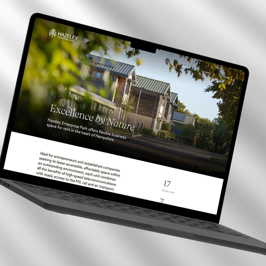 Laptop mock-up displaying the Hazely Enterprise Park website with a hero image of modern office buildings and the tagline “Excellence by Nature”