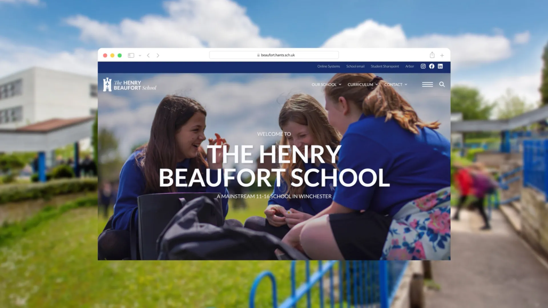 Browser window displaying The Henry Beaufort School homepage over a blurred campus background