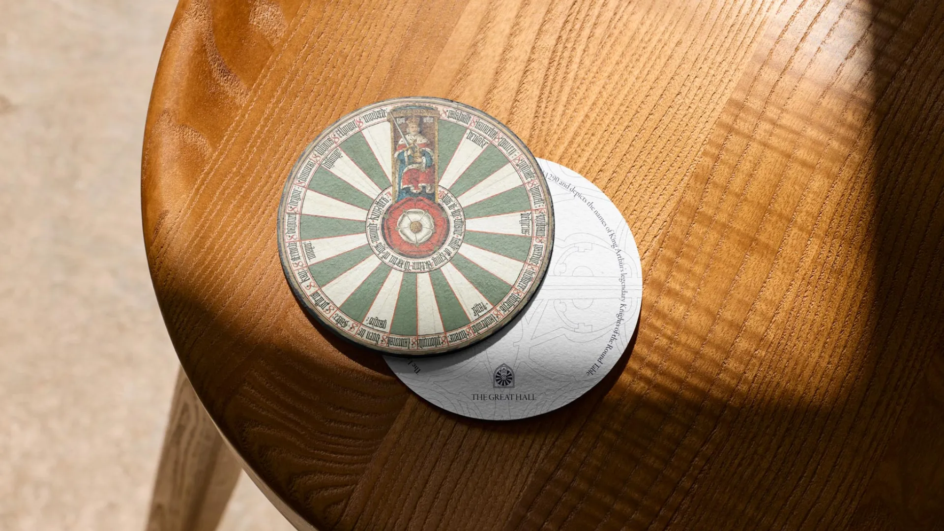 two drinks coasters on a wooden table featuring a design in green and white