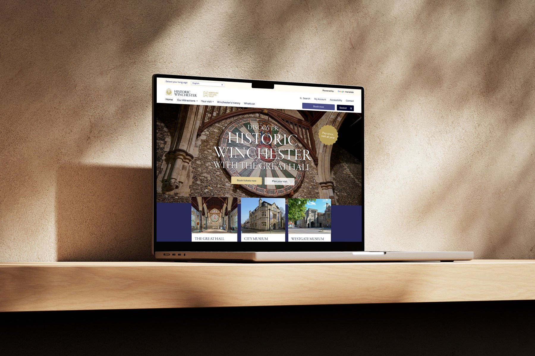 a rendering of a laptop on a pale background, on the screen is a mock up of the historic winchester website