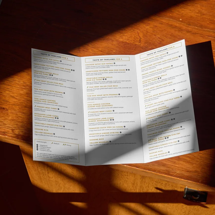 Bangkok trifold menu open on a wooden cabinet surface.
