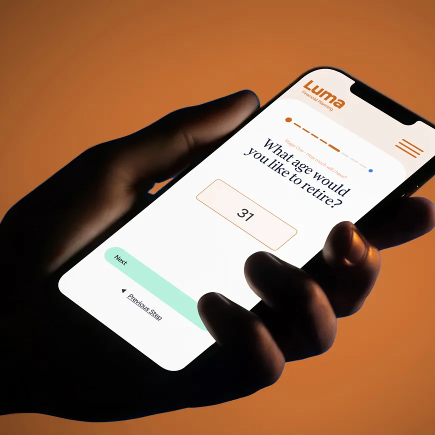 Hand holding a smartphone displaying the Luma Financial Planning retirement age calculator