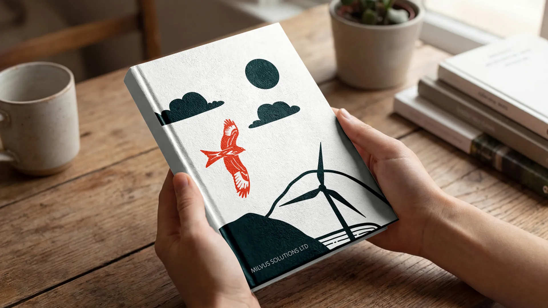 Illustrated cover of a red kite flying over a wind turbine on the cover of a white hardback notebook.