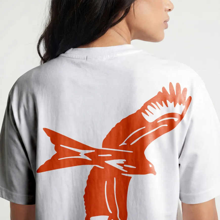 Lady wearing white t-shirt with red kite bird illustration across the back.