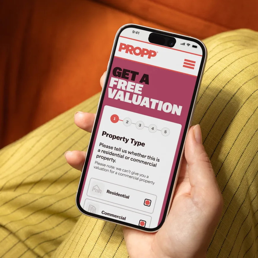 Hand holding mobile open on get a free valuation page