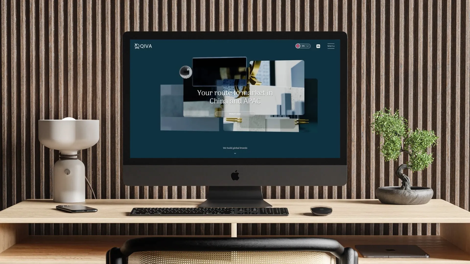 a mac computer screen on a wooden desk displaying the qiva global website