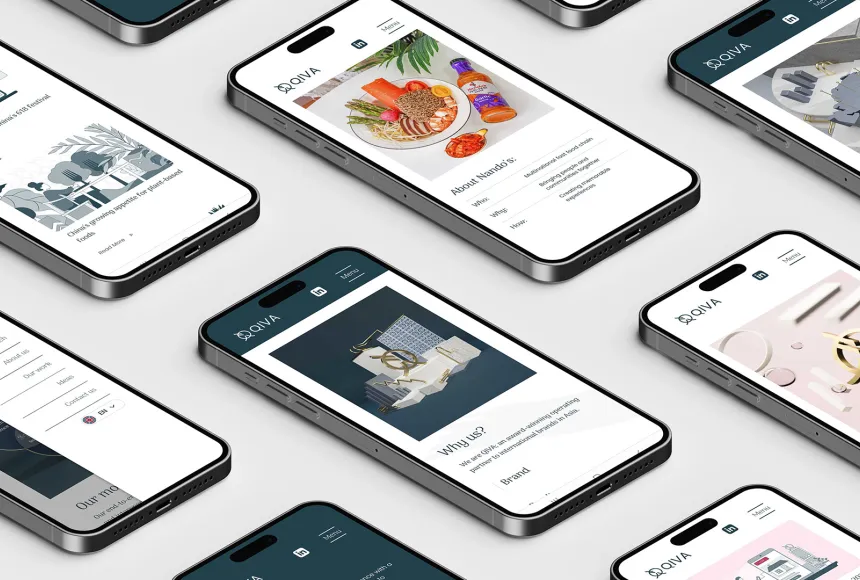 multiple mobile phones lay on a grey table displaying aspects of a website