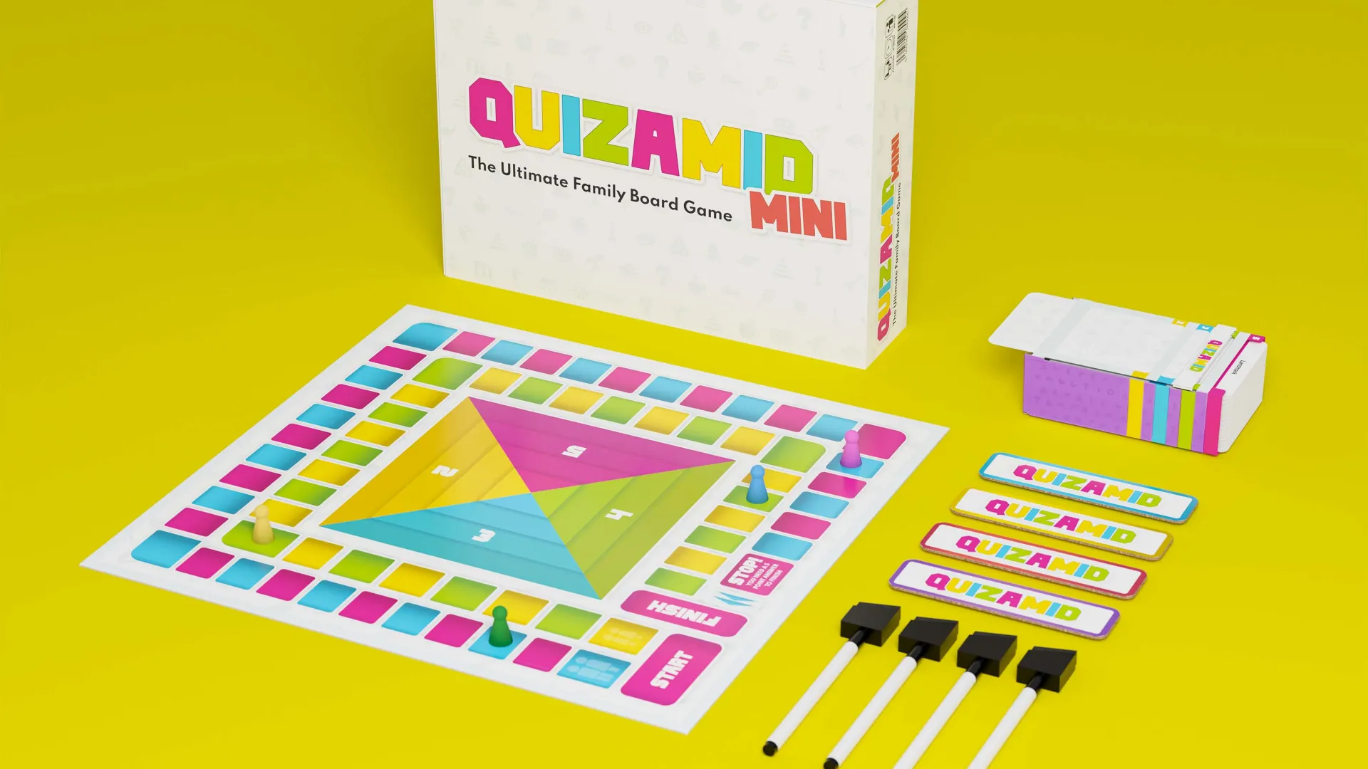 Quizamid mini board game box and board pieces laid out on yellow background.