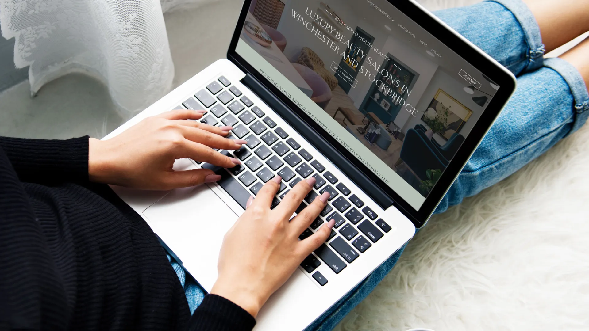 Woman using laptop on her lap sat on the floor