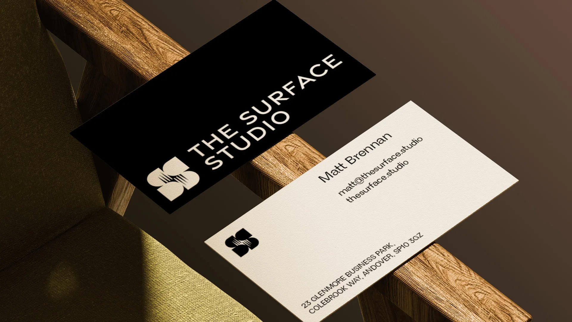 Branded business cards displayed on a wooden chair