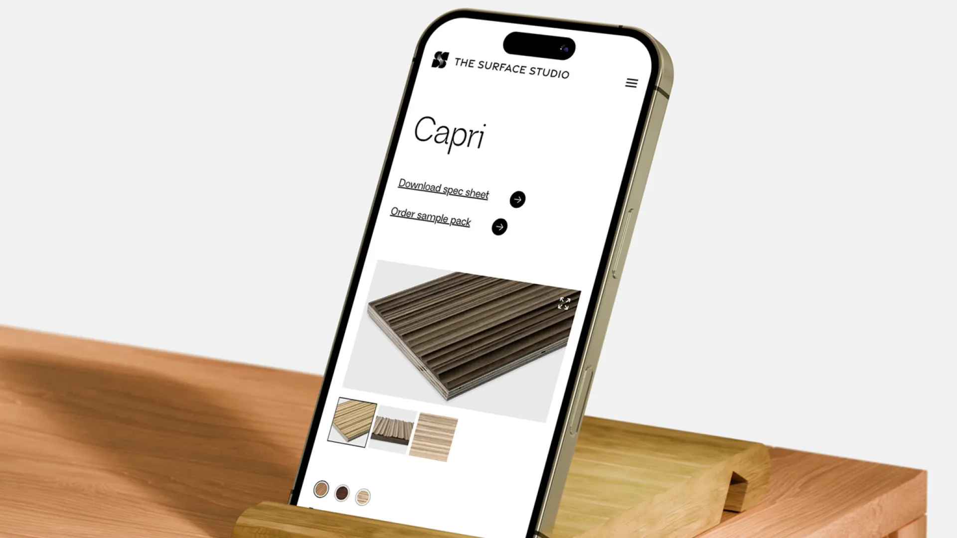 Smartphone displaying a product page in a wooden stand
