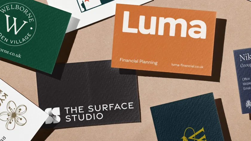 A collection of different companies business cards on a brown paper background.