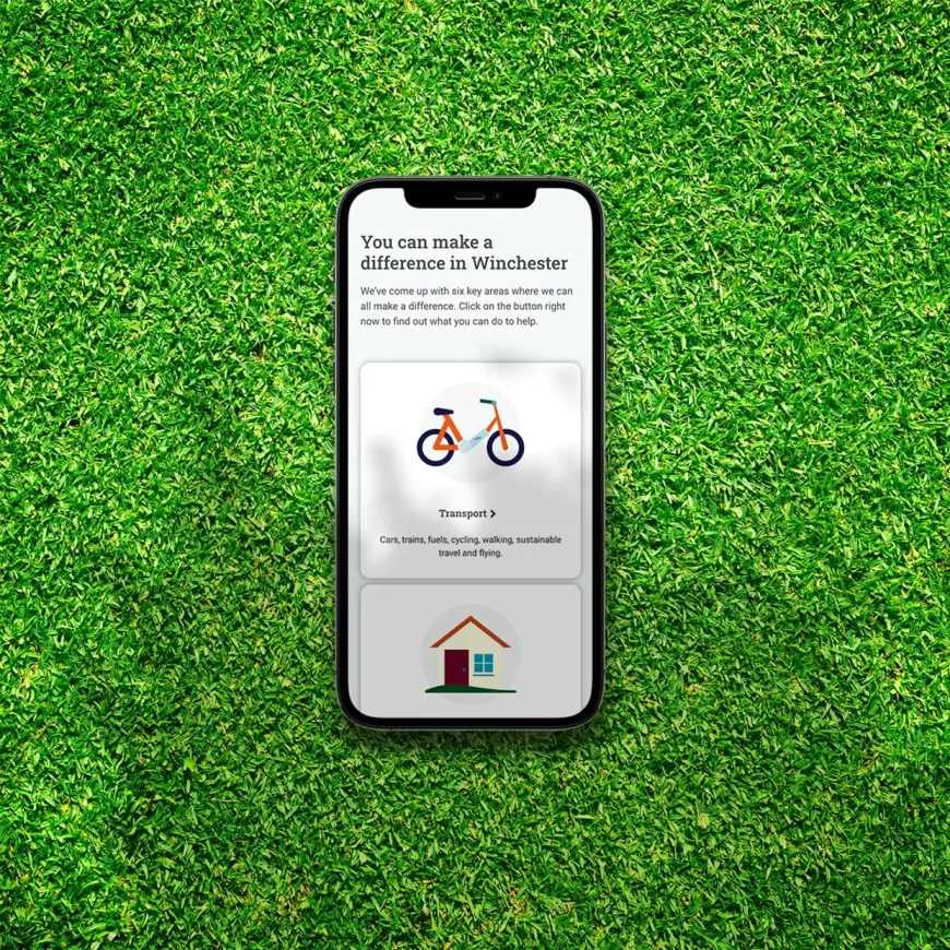 a mobile phone on green grass with a webpage visible