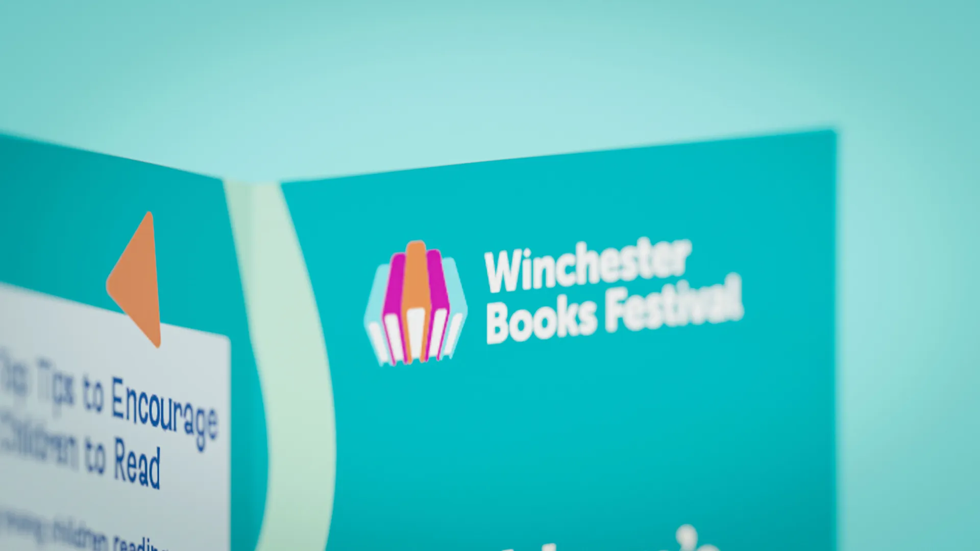 Close up of an open Winchester books festival leaflet and the brand logo