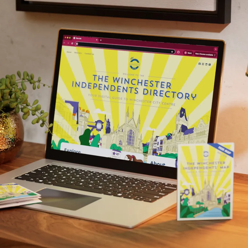 Laptop mockup displaying the Winchester Independents directory and map laid on table next to it.