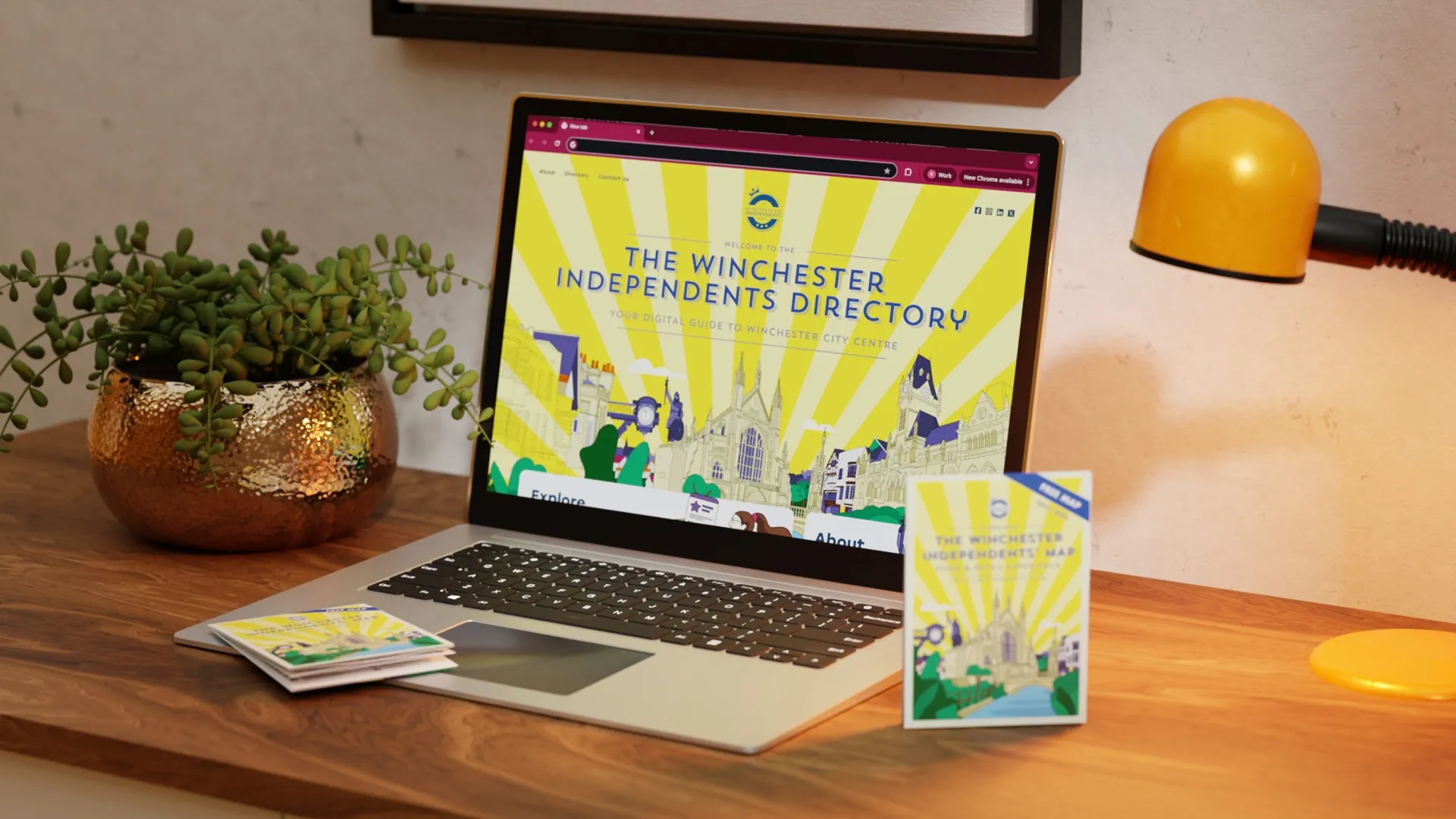Laptop mockup displaying the Winchester Independents directory and map laid on table next to it.
