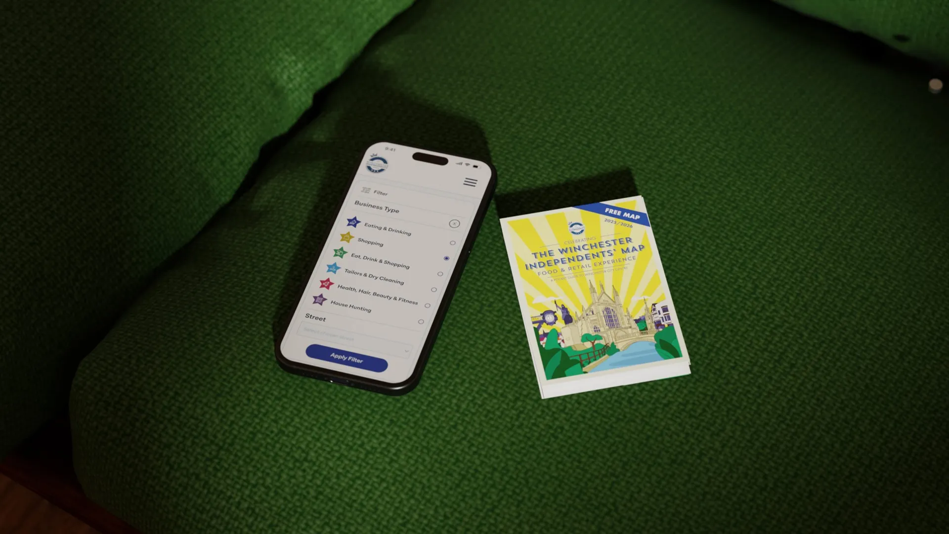 Mobile phone with search filter mockup and Winchester map on a green sofa.