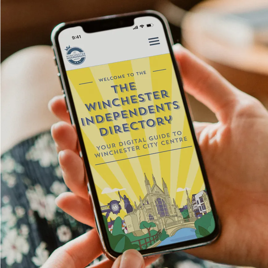 Person holding and mobile phone open on the Winchester independents directory home page.