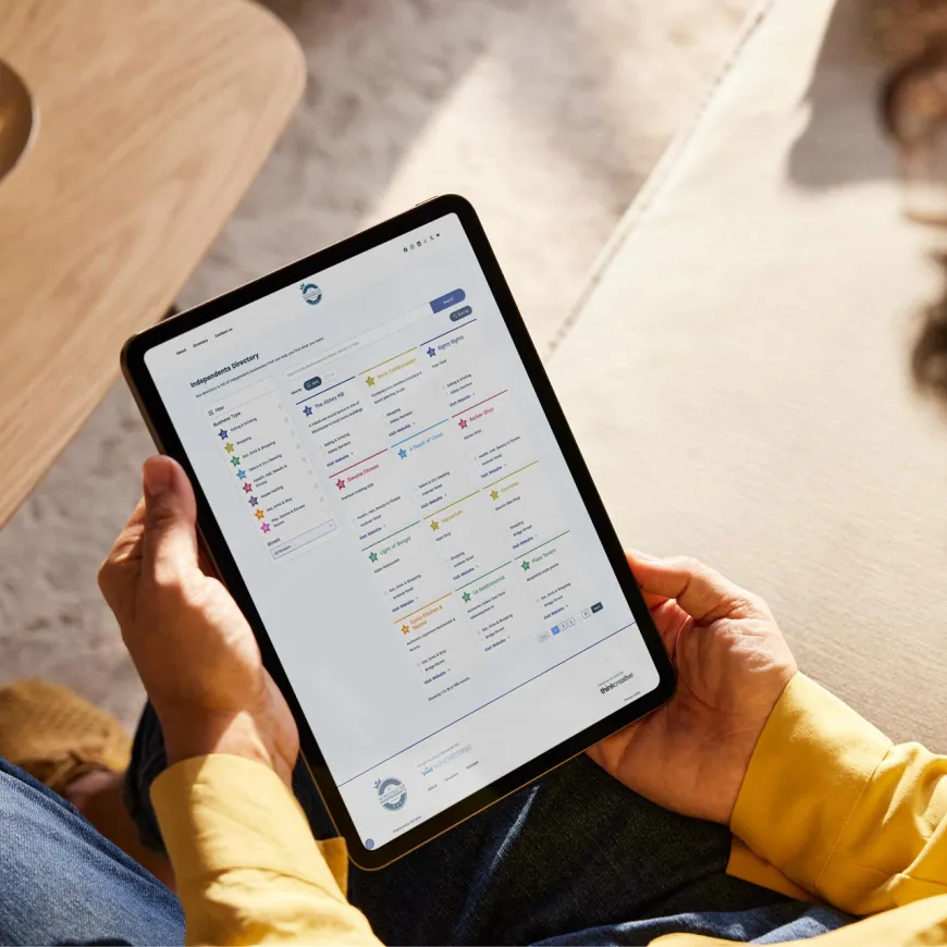 Person holding a tablet open on the independents directory page.