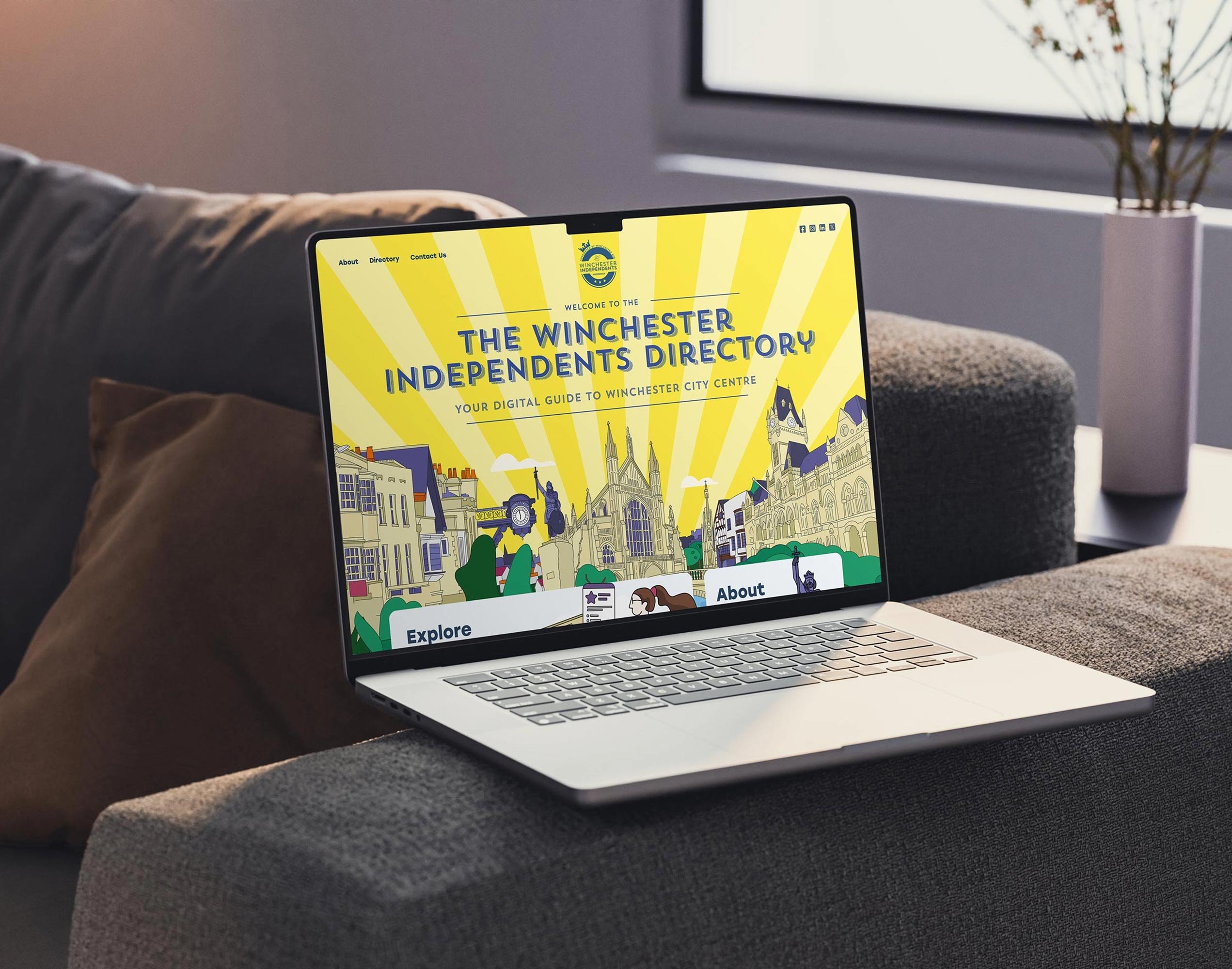 Laptop mockup for Winchester Independents on a sofa arm.